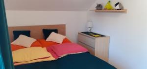 a bedroom with a bed with colorful pillows at Mieszkanko z tarasem in Limanowa