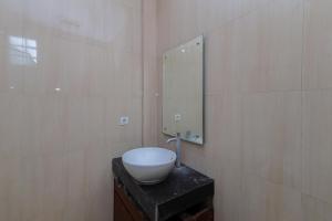 a bathroom with a bowl sink and a mirror at Urbanview Hotel WG Jimbaran Bali in Ungasan
