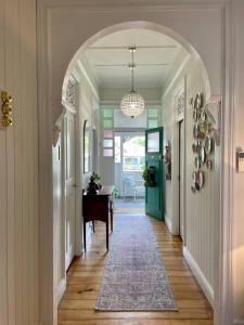 an archway in a hallway with a table and a room at Gorgeous Arthouse Queenslander In Ipswich in Bundamba