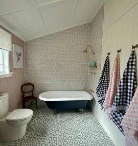 ein Bad mit einer Badewanne und einem WC in der Unterkunft Gorgeous Arthouse Queenslander In Ipswich in Bundamba