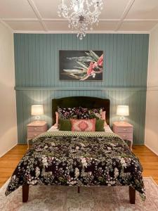 ein Schlafzimmer mit einem großen Bett mit zwei Nachttischen in der Unterkunft Gorgeous Arthouse Queenslander In Ipswich in Bundamba
