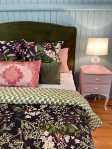 ein Schlafzimmer mit einem Bett und einem Nachttisch mit einer Lampe in der Unterkunft Gorgeous Arthouse Queenslander In Ipswich in Bundamba