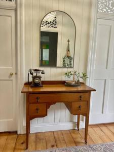 a dressing table with a mirror and a telephone on it at Gorgeous Arthouse Queenslander In Ipswich in Bundamba