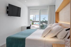 a bedroom with a bed with a television on a wall at Royal Hideaway Corales Suites in Adeje