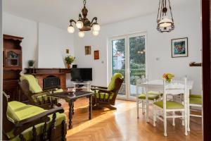 ペトルチャネにあるVilla Abbalinaのテーブルと椅子とテレビのあるリビングルーム