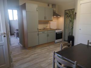 a kitchen with white cabinets and a table in a room at La Tour D'Elaine in Essertenne