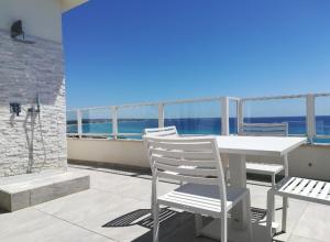 ガリポリにあるAttico Diamanteの白いテーブルと椅子、海を望むバルコニー