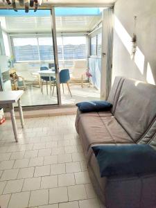 uma sala de estar com um sofá e uma mesa em Appartement climatise - grande terrasse em Le Grau-du-Roi