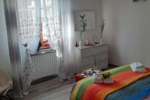 a room with a bed and a window with curtains at Ai piedi del Centro Storico in Castiglione del Lago