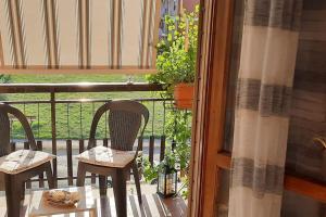 a porch with two chairs and a table on a balcony at Ai piedi del Centro Storico in Castiglione del Lago