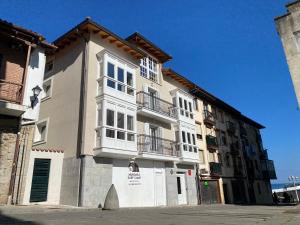 a large building with balconies on the side of it at Apartamentos Mundaka Surf Camp in Mundaka