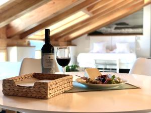 a glass of wine and a plate of food on a table at Apartamentos Mundaka Surf Camp in Mundaka