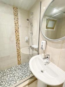 y baño con lavabo y ducha con espejo. en Antonis G. Hotel Apartments en Voroklini