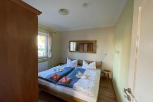 a bedroom with a bed with a blue comforter at Ferienwohnung OTTOSIN mit Terrasse und Garten in Dargen +5 photos