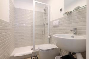 a white bathroom with a toilet and a sink at Residenza Mazzini in Rome
