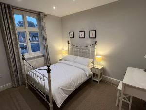 a bedroom with a white bed and a window at Central Knutsford in Knutsford