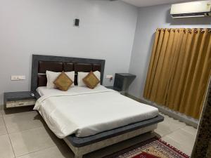 a bedroom with a large bed and a curtain at Ruturaj Inn Alibag in Alibaug