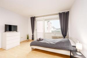 um quarto com uma cama e uma grande janela em Cosy Apartment near Lippstadt em Geseke