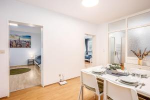uma sala de jantar branca com uma mesa e cadeiras brancas em Cosy Apartment near Lippstadt em Geseke