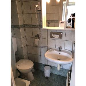 a small bathroom with a sink and a toilet at Hotel Balaton Fonyód in Fonyód