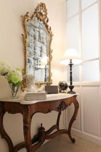 a table with a mirror and a lamp on it at Residenza Mazzini in Rome