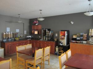 a kitchen with a table and chairs and a refrigerator at Lakeview Inns & Suites - Fort Nelson in Fort Nelson