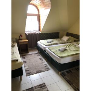 2 łóżka pojedyncze w pokoju z oknem w obiekcie Hotel Balaton Fonyód w mieście Fonyód