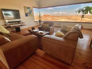 - un salon avec deux canapés et une grande fresque murale dans l'établissement Desert Breeze Lodge, à Swakopmund