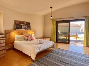 een slaapkamer met een bed en een glazen schuifdeur bij Desert Breeze Lodge in Swakopmund