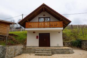 ein kleines Haus mit Balkon darüber in der Unterkunft Koča na Kučarju / House on a Hill in Gradac