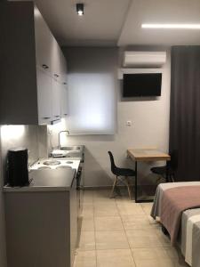 uma pequena cozinha com uma cama e uma mesa num quarto em Vv Cosy Host 1 em Lárissa