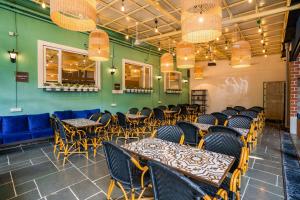 restauracja ze stołami i krzesłami oraz zielonymi ścianami w obiekcie Zostel Mumbai w Bombaju