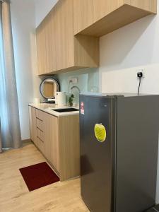a kitchen with a stainless steel refrigerator with a yellow sticker on it at NJ Homestay @ Colony By Infinitum in Kuala Lumpur