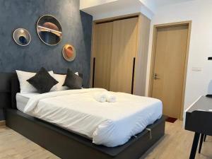 a bedroom with a large bed with two towels on it at NJ Homestay @ Colony By Infinitum in Kuala Lumpur