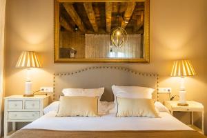 a bedroom with a bed with two lamps and a mirror at Hotel Palacio De Luko in Luco