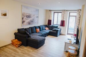 a living room with a blue couch and a tv at La Pommeraie in Mettet