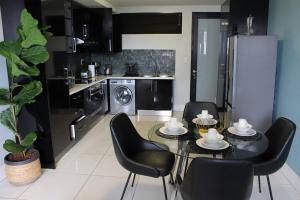 a kitchen with a table and chairs and a kitchen with a refrigerator at Favour's 2 Bedroom Apartment on 77 in Windhoek