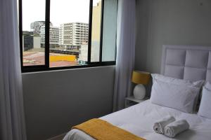 a bedroom with a bed with two towels on it at Favour's 2 Bedroom Apartment on 77 in Windhoek +28 photos