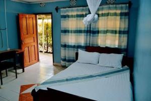 1 dormitorio con 1 cama con pared azul en HILLVIEW ECO-TOURISM RESORT, en Bungoma