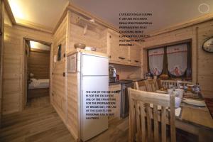 cocina con nevera y mesa con sillas en B & B Le Riue, en Aprica