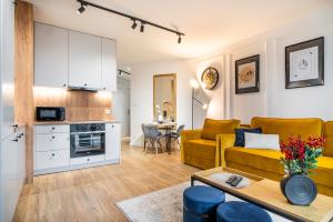 - un salon avec un canapé jaune et une table dans l'établissement ApartamentySnu, Struga Tower Gold z parkingiem, à Radom