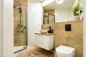 a bathroom with a shower and a toilet and a sink at ApartamentySnu, Struga Tower Gold z parkingiem in Radom