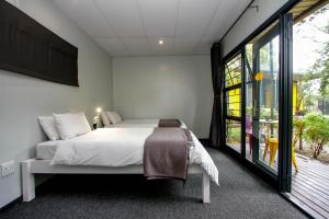 a bedroom with a bed and a large window at SleepOver Lanseria in Lanseria