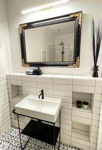 a white bathroom with a sink and a mirror at historical Zaffir house - market square in Levoča