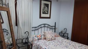 Schlafzimmer mit einem Bett und einem Spiegel in der Unterkunft Casa Rural Fray Eloy in Guadalupe