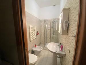 biała łazienka z umywalką i toaletą w obiekcie De Gasperi House w mieście Napoli