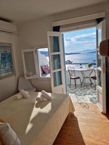 a bedroom with a bed and a view of the ocean at Anemones Sea View in Mikonos