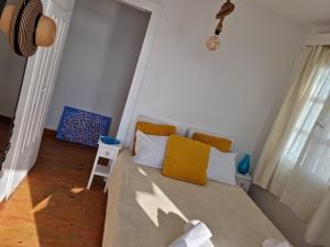 a small bedroom with a bed with yellow pillows at Anemones Sea View in Mikonos