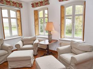 - un salon avec des chaises, une table et des fenêtres dans l'établissement Gutshaus Glowitz, à Glowitz