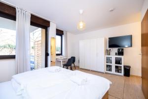 a bedroom with a white bed and a desk at Nettes Apartment mit Terrasse in Würzburg